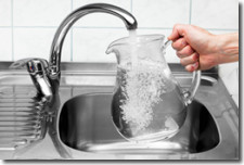Photo of pitcher being filled with water from a kitchen sink faucet